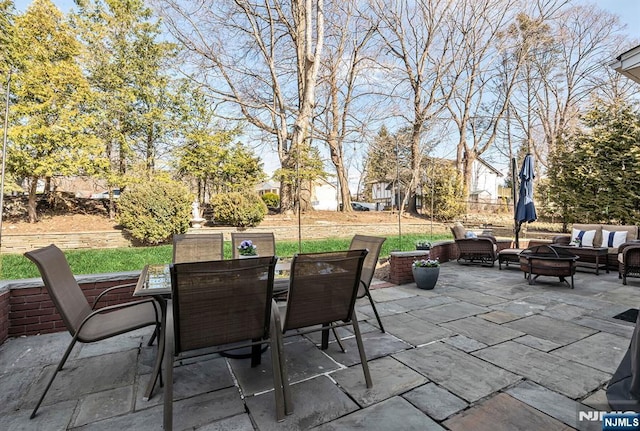 view of patio featuring outdoor dining space and an outdoor living space with a fire pit