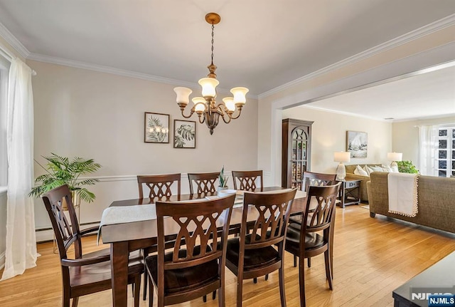 dining space with a chandelier, light wood-style floors, baseboard heating, and ornamental molding