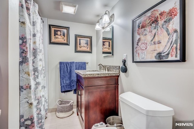 bathroom featuring toilet, a shower with shower curtain, and vanity