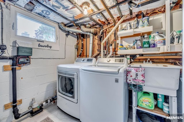 laundry area with laundry area, a sink, and washing machine and clothes dryer