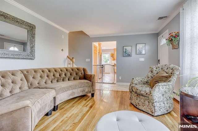 living room with baseboards, visible vents, wood finished floors, crown molding, and a baseboard heating unit