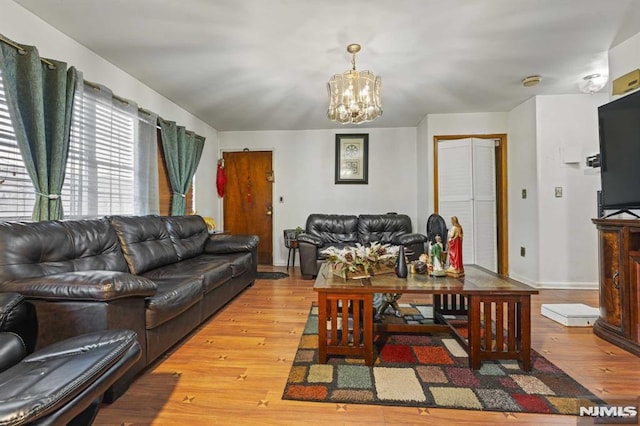 living room featuring a chandelier, light wood-style flooring, and baseboards