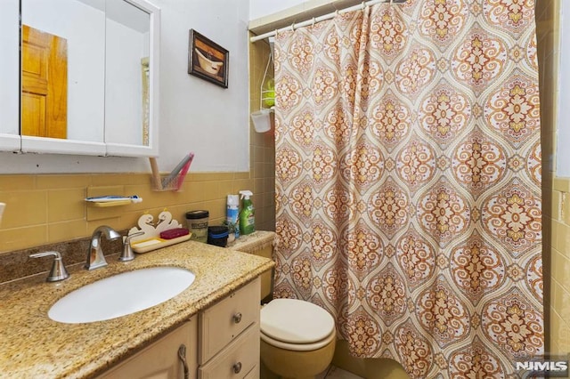 bathroom with a shower with curtain, tile walls, toilet, and vanity