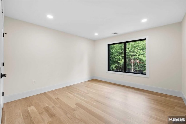 spare room with recessed lighting, light wood-type flooring, visible vents, and baseboards