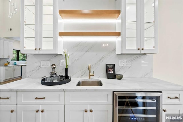 kitchen featuring wine cooler, white cabinets, and a sink