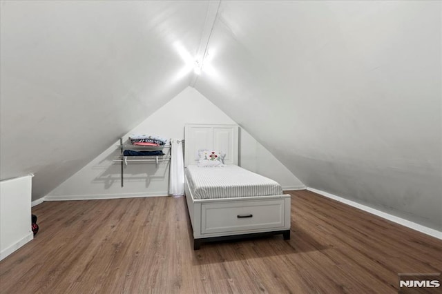 bedroom featuring vaulted ceiling, wood finished floors, and baseboards