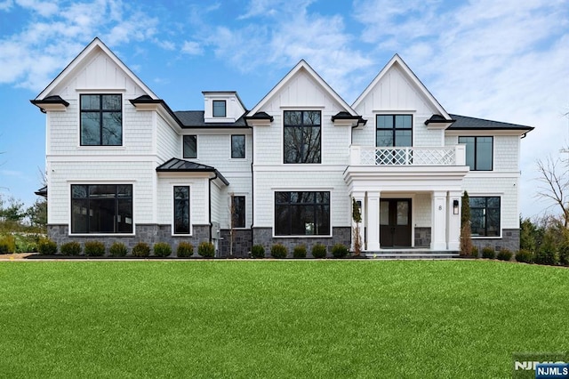 view of front of property featuring board and batten siding, a front yard, and a balcony