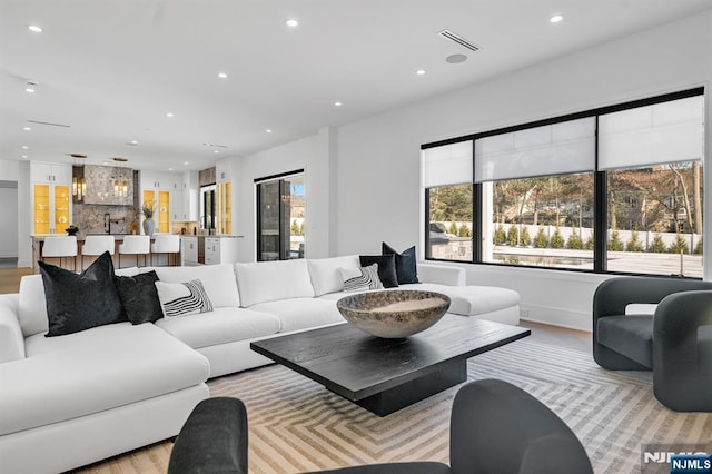 living area with recessed lighting, visible vents, and plenty of natural light