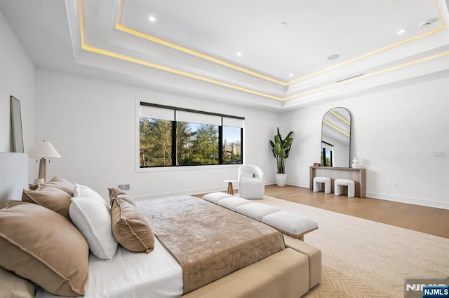 bedroom with recessed lighting, a raised ceiling, visible vents, wood finished floors, and baseboards