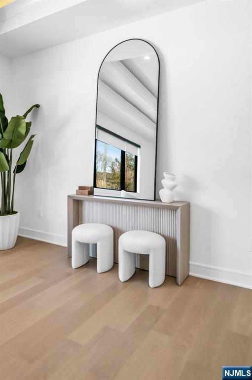 room details with radiator, baseboards, and wood finished floors