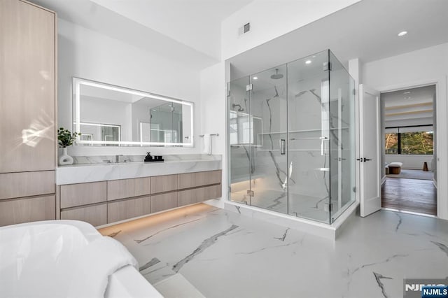 full bathroom featuring marble finish floor, a marble finish shower, visible vents, and vanity