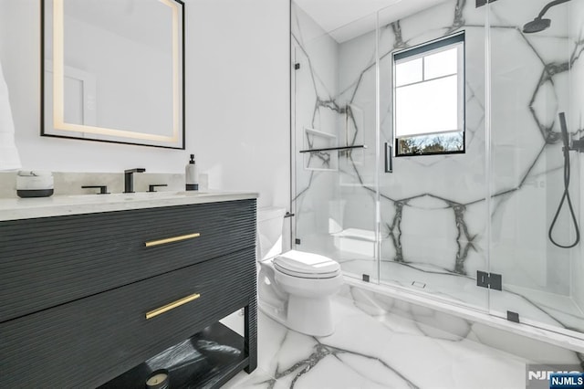 full bath featuring marble finish floor, vanity, a marble finish shower, and toilet