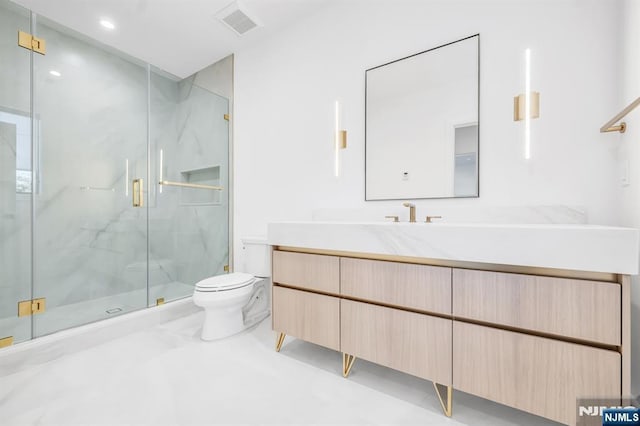 bathroom featuring toilet, a marble finish shower, visible vents, and vanity