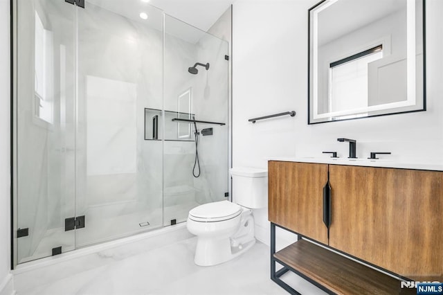 bathroom with toilet, a marble finish shower, and vanity