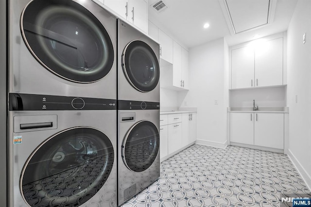 washroom with stacked washer and clothes dryer, recessed lighting, visible vents, cabinet space, and baseboards