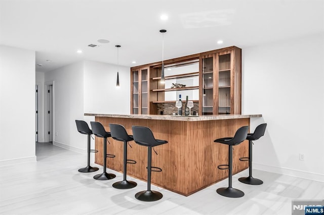 bar with recessed lighting, indoor wet bar, and baseboards