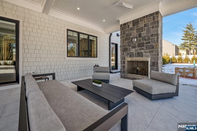 view of patio / terrace featuring an outdoor living space with a fireplace and a ceiling fan