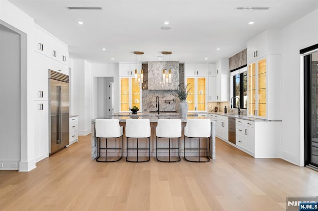 kitchen with light wood finished floors, stainless steel appliances, tasteful backsplash, and a breakfast bar area