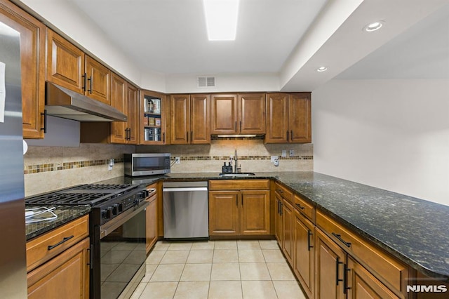 kitchen featuring visible vents, under cabinet range hood, light tile patterned floors, appliances with stainless steel finishes, and a sink