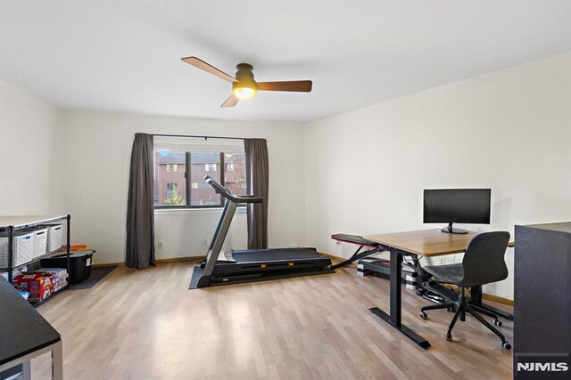 home office with a ceiling fan, wood finished floors, and baseboards