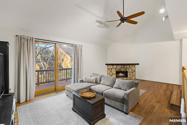 living area with a fireplace, a ceiling fan, lofted ceiling, and hardwood / wood-style floors