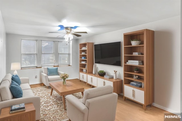 living room with ceiling fan, light wood-type flooring, and baseboards