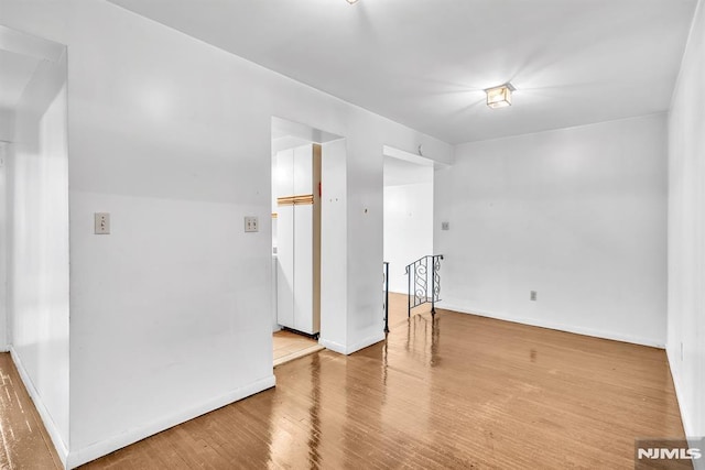 spare room featuring wood finished floors and baseboards