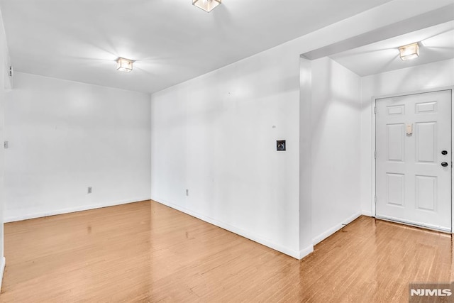 spare room featuring baseboards and wood finished floors