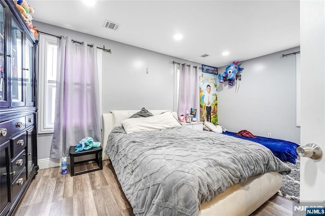 bedroom with light wood finished floors, visible vents, recessed lighting, and baseboards