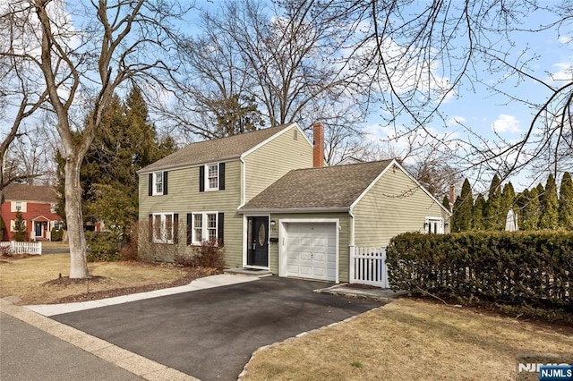 view of front of home featuring an attached garage, a shingled roof, fence, driveway, and a chimney