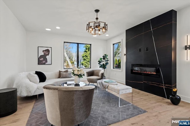 living area with baseboards, a fireplace, wood finished floors, and recessed lighting