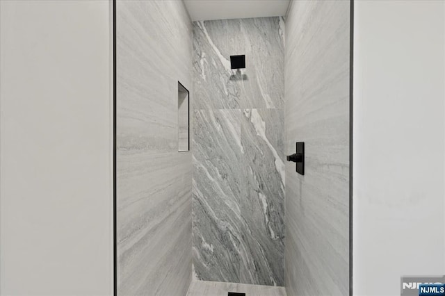 bathroom with a marble finish shower