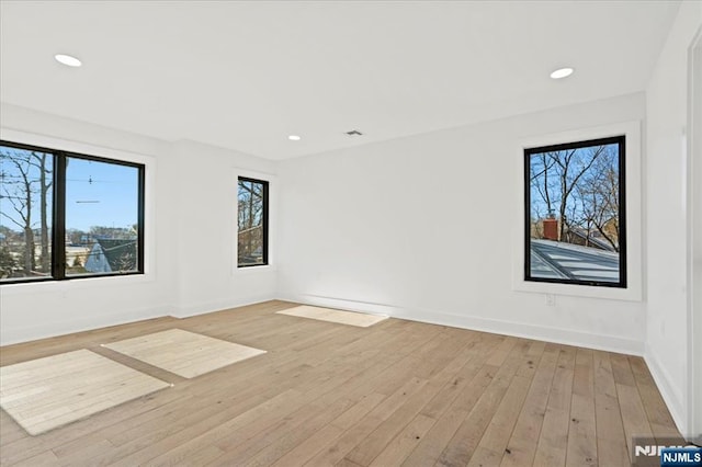 spare room with light wood-style flooring, baseboards, and recessed lighting