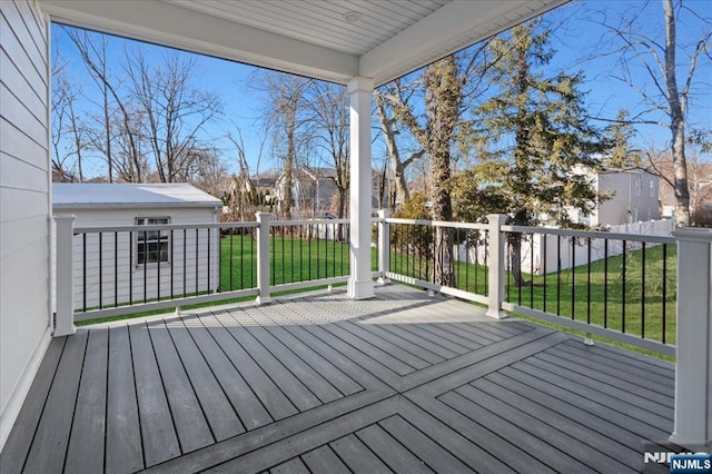 wooden terrace with a yard, an outdoor structure, and a residential view