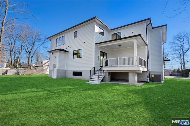 rear view of property with cooling unit and a lawn