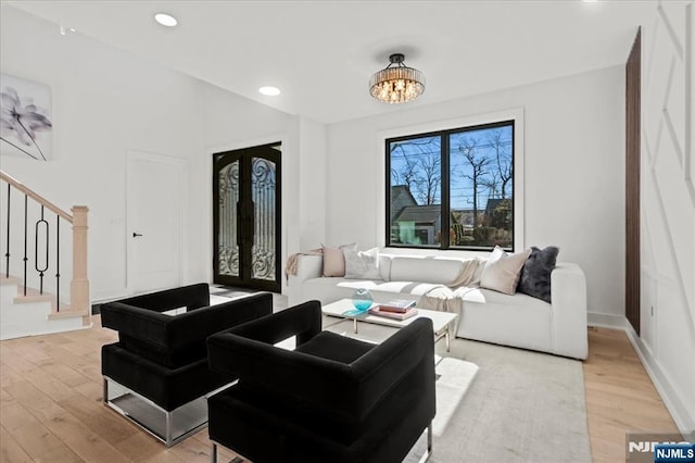 living room with light wood-style floors, recessed lighting, stairway, and french doors