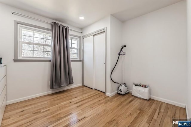 bedroom with recessed lighting, a closet, light wood-style flooring, and baseboards