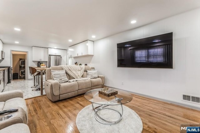 living room with light wood-style floors, recessed lighting, and visible vents