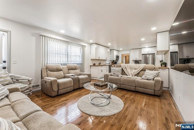 living room featuring light wood finished floors and recessed lighting