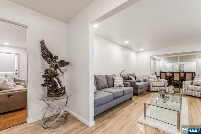 living room featuring light wood-style flooring, baseboards, and recessed lighting