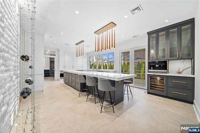 kitchen with recessed lighting, visible vents, decorative backsplash, glass insert cabinets, and pendant lighting