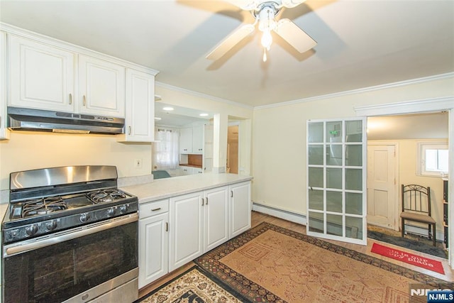 kitchen with under cabinet range hood, white cabinets, light countertops, baseboard heating, and stainless steel range with gas stovetop