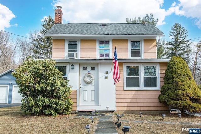 view of front of property featuring a shingled roof and a chimney