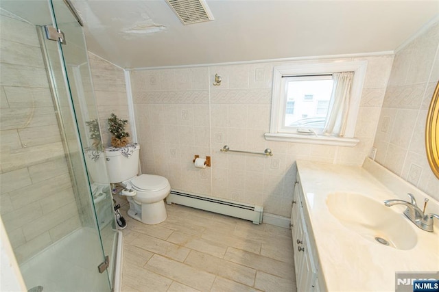 full bathroom featuring vanity, baseboard heating, a shower stall, and tile walls