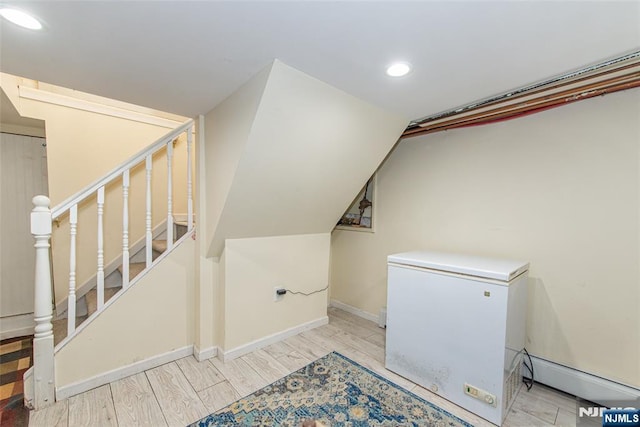 laundry area featuring baseboards, wood finished floors, and recessed lighting