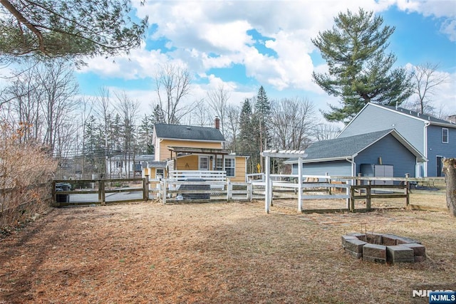 view of yard featuring an outdoor fire pit, a gate, a pergola, and fence private yard