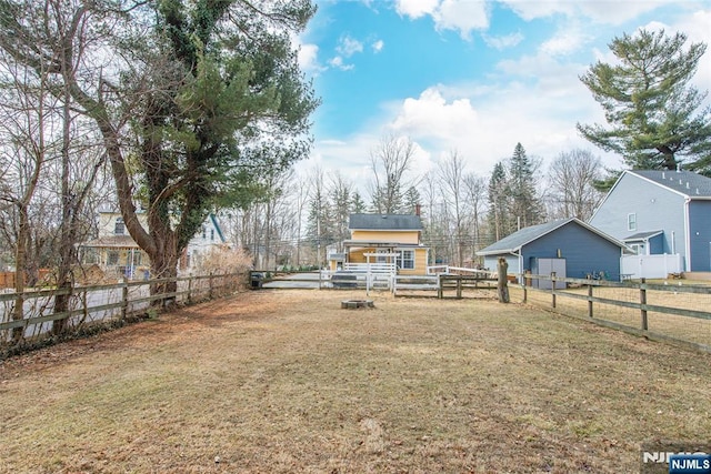 view of yard with a fenced backyard and an outbuilding