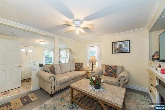 living area featuring ceiling fan, ornamental molding, and baseboards