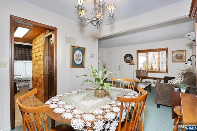 carpeted dining area featuring ornamental molding, a chandelier, and visible vents