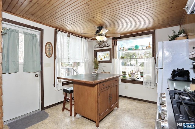 kitchen featuring stainless steel stove, wood ceiling, brown cabinetry, and tile counters